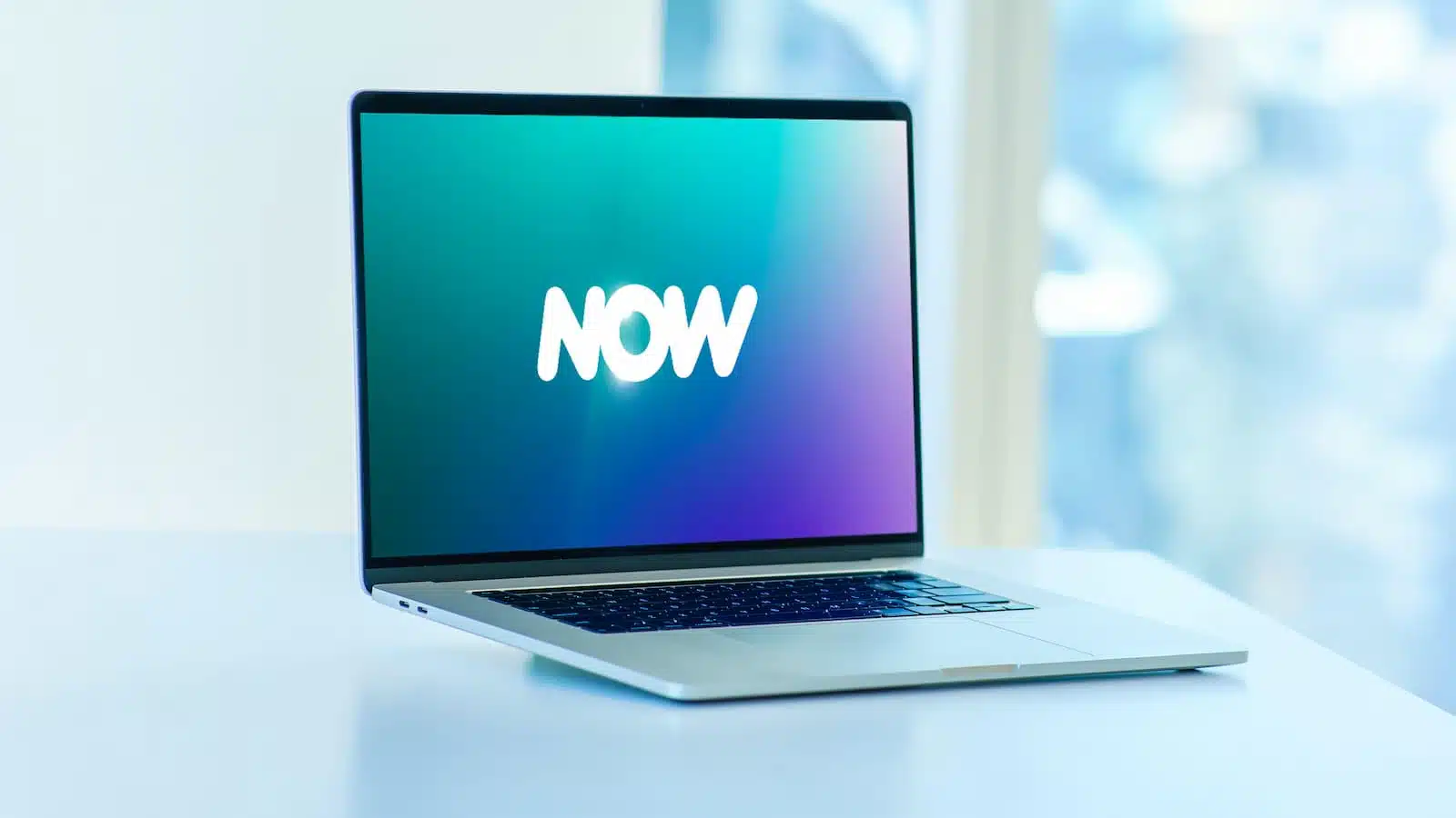 Laptop op bureau met de tekst "NOW"