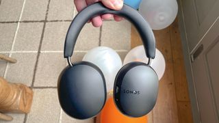 Afbeelding van de Sonos Ace koptelefoonrecensie in het zwart met ballonnen op de achtergrond